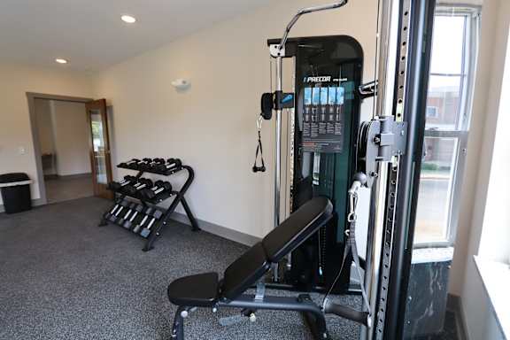 A gym with a weight machine and a bench.