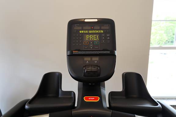 A treadmill display shows the word "PRE" on the screen.