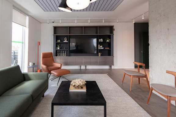 A living room with a green couch, a black coffee table, and a grey sofa.