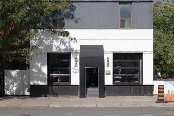 the front of a white building with a black door