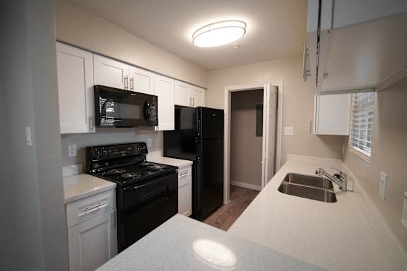 a kitchen with black appliances and white counter tops