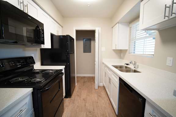 a kitchen with white cabinets and black appliances and a black refrigerator