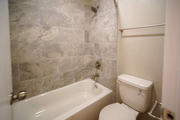 a small bathroom with a toilet and a bath tub