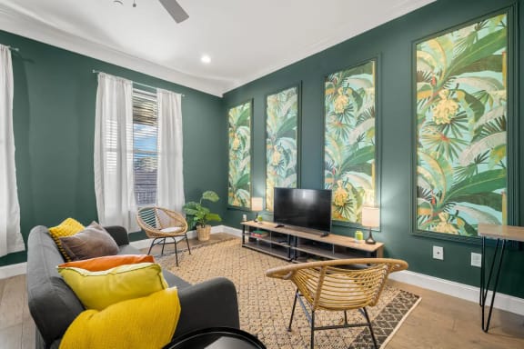 a living room with green walls and a television