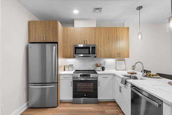 A modern kitchen with wooden cabinets and stainless steel appliances.