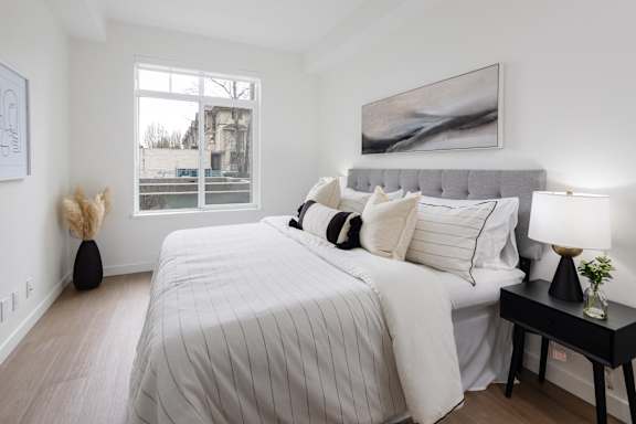 A bedroom with a large bed and a painting on the wall.