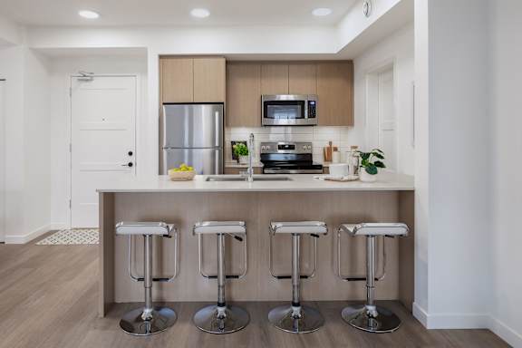 A kitchen with a bar stool in front of it.
