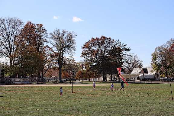 a group of children flying a kite in a field
