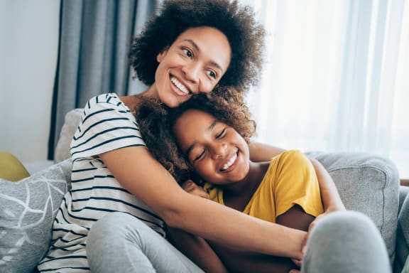 a woman and a girl laying on a couch