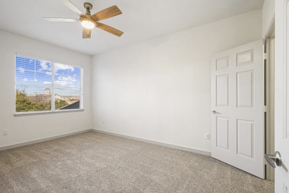 an empty living room with a ceiling fan and a window at The Legends at Eagle Mountain Lake, Fort Worth, TX, 76179