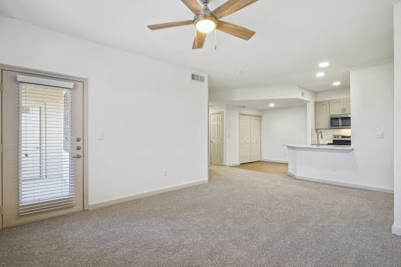 an empty living room with a ceiling fan and a kitchen at The Legends at Eagle Mountain Lake, Fort Worth, TX, 76179