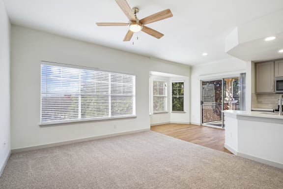 an empty living room with a ceiling fan and a kitchen at The Legends at Eagle Mountain Lake, Fort Worth, TX, 76179