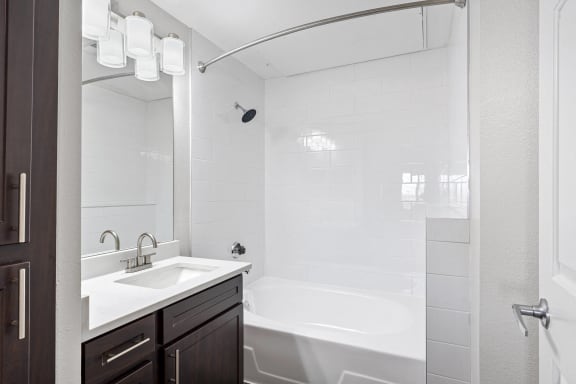 a bathroom with a tub and a sink and a mirror at The Legends at Eagle Mountain Lake, Texas, 76179