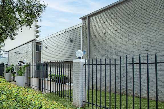 the side of a brick building with a wrought iron fence