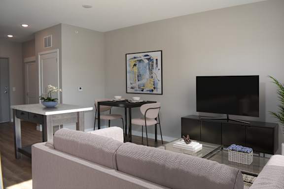 A living room with a couch, a table, a chair, a television, and a painting on the wall.