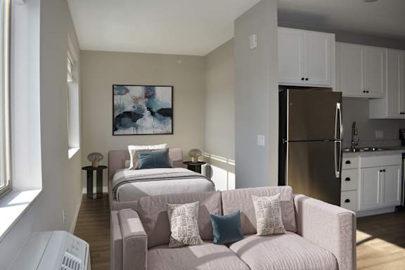 A living room with a couch and a painting on the wall.