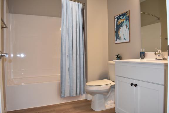 A white toilet sits next to a white sink in a bathroom.