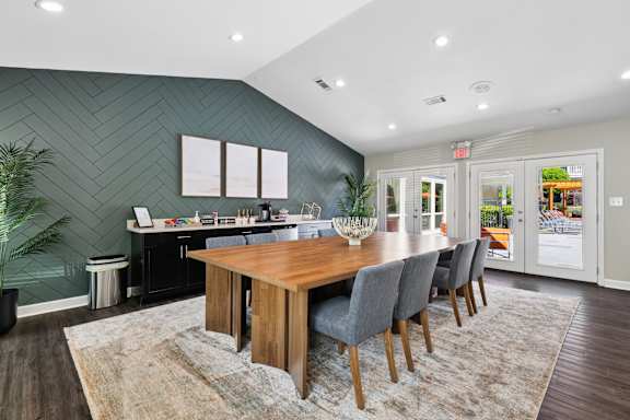 A dining room with a wooden table and grey chairs.