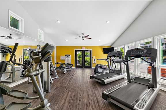 A gym with treadmills, elliptical machines, and other exercise equipment.