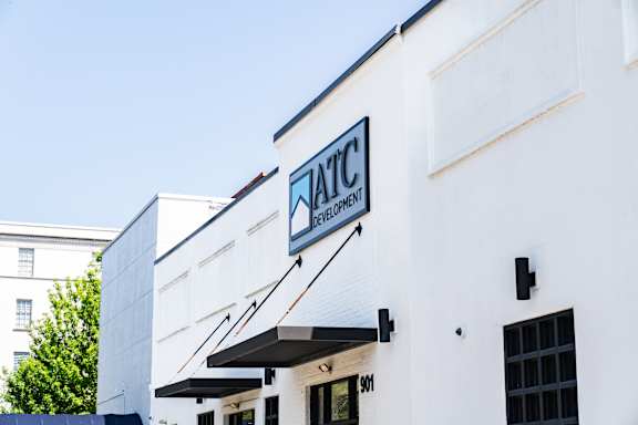 A white building with a black awning and a sign that says "NATC Innovation Center.".
