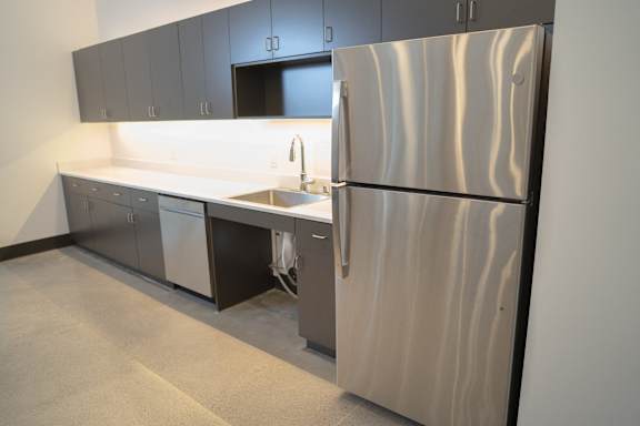 an empty kitchen with a refrigerator and a sink