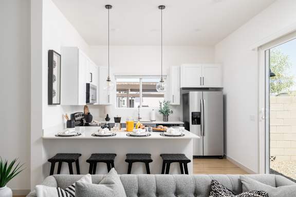 A modern kitchen with a breakfast table set for four.