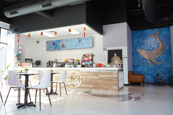 a restaurant with a bar and a blue mural on the wall
