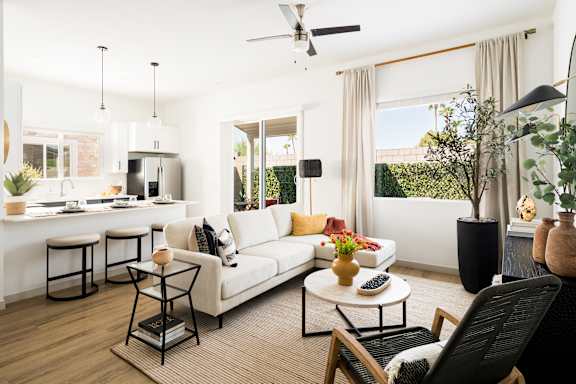 A modern living room with a white sofa, a black chair, and a coffee table.