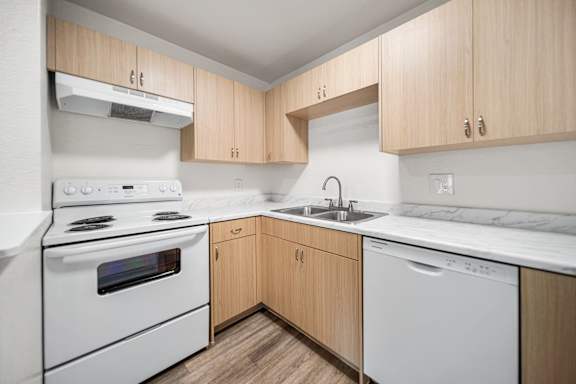 A kitchen with wooden cabinets and white appliances.