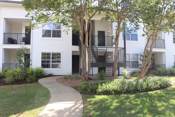 a view of a white house with a yard and stairs at The Vineyard at Castlewoods Apartment Homes in Brandon, MS 39047
