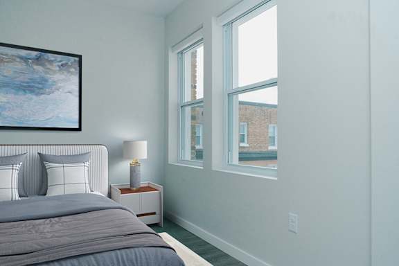 A bedroom with a large bed and a painting on the wall.