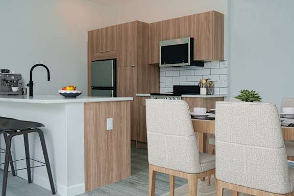 A kitchen with a bar stool and a table with two chairs.