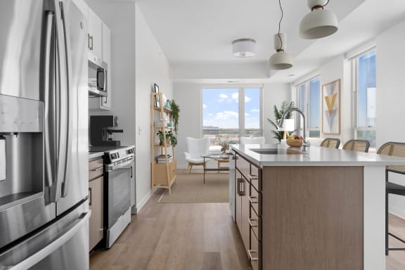 an open kitchen with a large island and a dining room with a table and chairs