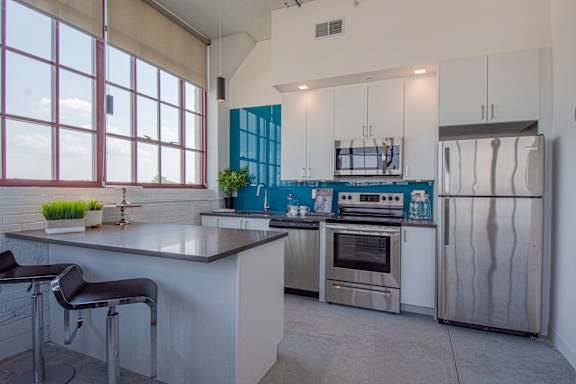 A modern kitchen with stainless steel appliances and a large island.