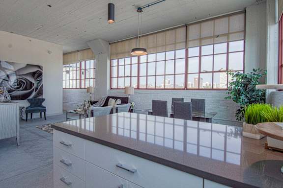 A modern kitchen with a long counter and a large window.