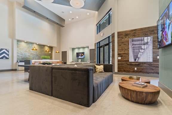 A modern living room with a large sectional sofa and a wooden coffee table.
