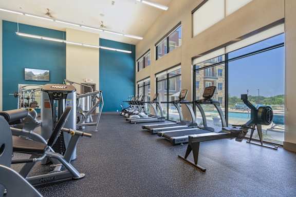 A gym with treadmills, exercise bikes, and other equipment.