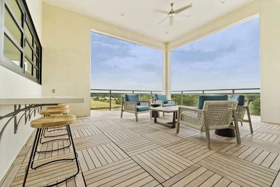 A patio with a table and chairs overlooking the ocean.