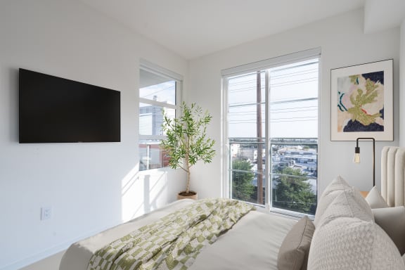 a bedroom with a bed and a tv on the wall