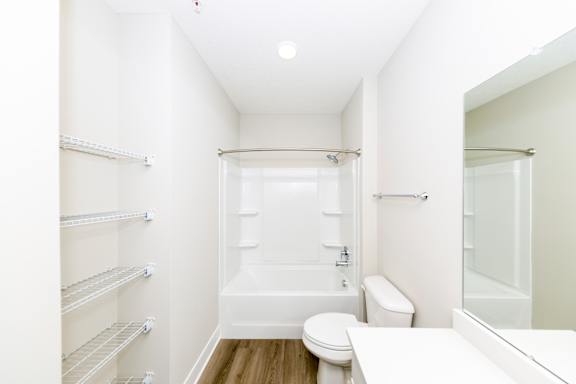 A white bathroom with a toilet, sink, and bathtub.