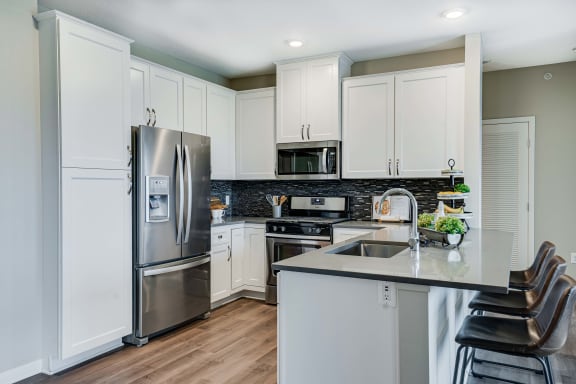 Spacious kitchen with premium design scheme with quartz countertops of 2 bedroom apartment for rent at Ascend at Woodbury best new apartments Woodbury MN 55129