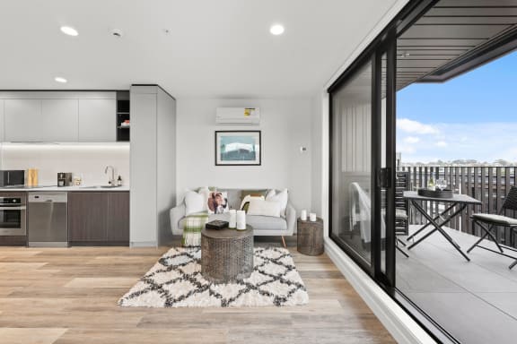 a kitchen and living room with a balcony and a sink