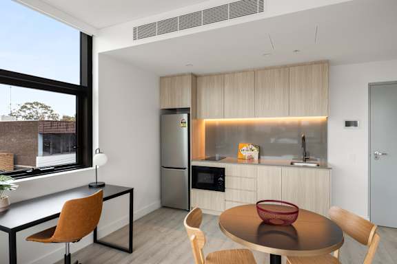 A modern kitchen with a table and chairs.