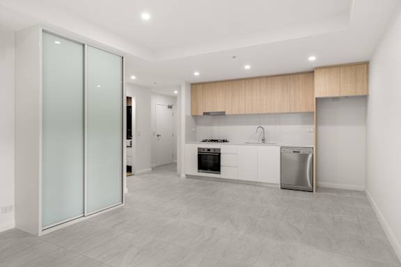A modern kitchen with a dining table set for two.