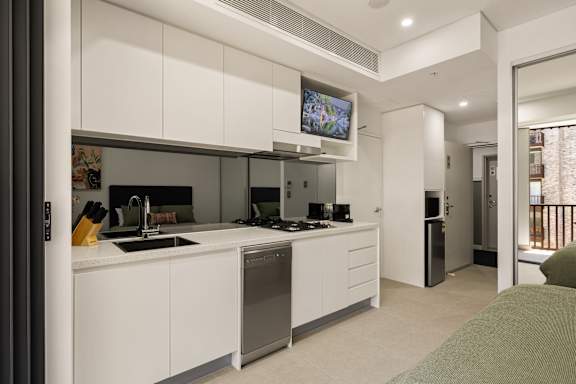 A modern kitchen with white cabinets and stainless steel appliances.