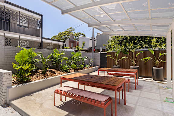 A patio with a table and chairs under a white awning.