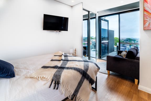 a bedroom with a bed and a tv on the wall