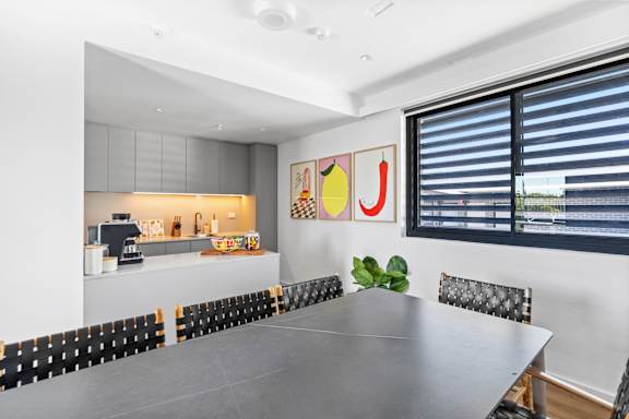 A modern dining room with a large table and chairs.