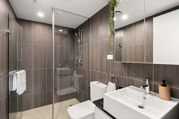 A modern bathroom with a walk-in shower and a white toilet.