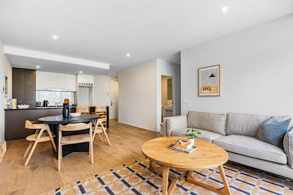 A modern living room with a grey sofa and a wooden coffee table.